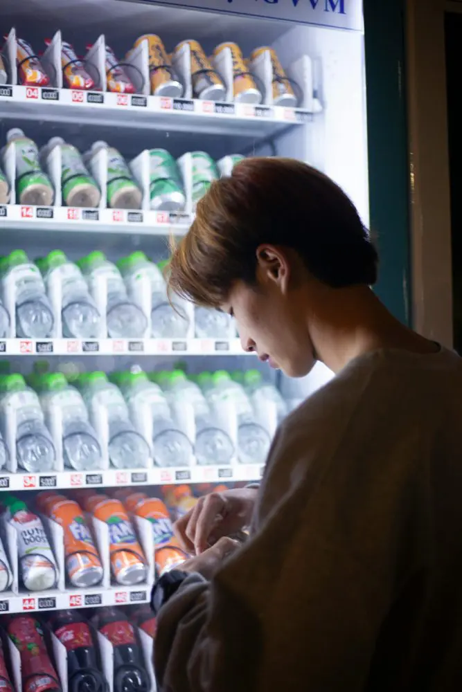 A man standing on a vending machine with drinks